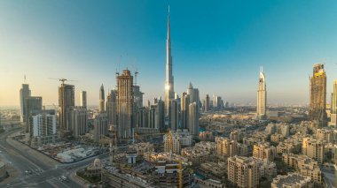 Güzel lüks günbatımı timelapse, Dubai, Birleşik Arap Emirlikleri Dubai şehir merkezinde hava en iyi manzaraya. Defne iş kuleleri renkli bulutların üstünde turuncu gökyüzü ile çatı manzara. Yolda trafik