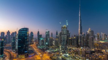 Dubai Şehir Merkezi 'nden geceye geçiş zamanı. Gece vakti büyük, fütüristik şehir üzerinde hava manzarası. Dubai 'nin gökdelenleri, Birleşik Arap Emirlikleri. Akşam gökyüzü çatıdan yükseliyor