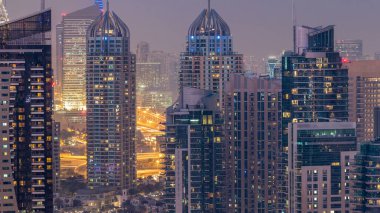 Dubai, Birleşik Arap Emirlikleri güneş battıktan sonra gece geçiş timelapse Dubai Marina günler güzel hava üstten görünüm. Modern kuleleri ve yolda trafik.