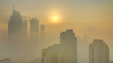 Sisli sabah gündoğumu Dubai timelapse şehir merkezinde. Şehir gökdelenler fütüristik görünümünü sis kaplı. Çatı modern kuleli havadan görünümden. Dubai, Birleşik Arap Emirlikleri