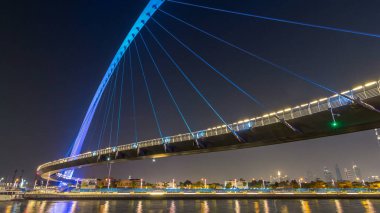 Fütüristik Dubai su kanal ışıklı gece timelapse hyperlapse, Birleşik Arap Emirlikleri, üzerinde yaya köprüsü. Cityscape arka plan üzerinde. Promenade görüntülemek