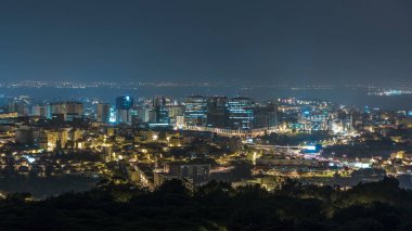 Overview of Lisbon and Almada from a viewpoint in Monsanto night timelapse. Aerial top panorama with traffic on illumitated city streets