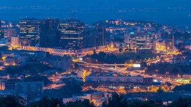 Lizbon ve Almada üzerinde panoramik şafak manzarası Monsanto 'da gece gündüz geçiş zamanı. Trafikli hava manzarası ve alışveriş merkezi olan modern binalar.