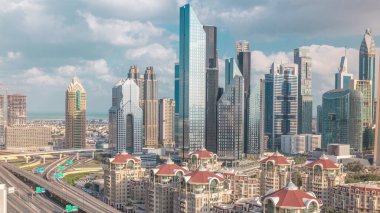 Dubai timelapse gökdelenler ve yol kavşağı havadan görünümü. Etrafında modern kuleleri ile şehir merkezinde kavşakta Trafik. Bulutlu gökyüzü