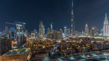 Dubai Şehir Merkezi Ufuk Çizgisi gecesi Burj Halife ve diğer panoramik manzaralı Dubai, Birleşik Arap Emirlikleri. Çember yollarda ve çeşmelerde trafik vardı. Geleneksel ve modern binalar.