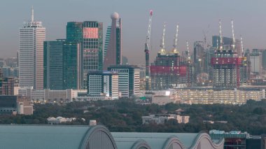 Dubai şehir merkezi mimarisi ile Aerial cityscape ve günlük geçiş timelapse, Birleşik Arap Emirlikleri finans merkezi gece. Şantiye ile en yüksek kuleler ve gökdelenler