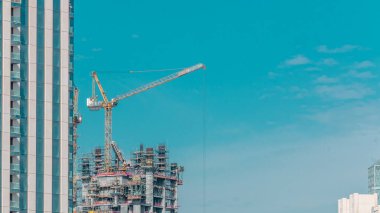 Dubai timelapse büyük vinçler ile yapım aşamasında bir gökdelenhavadan görünümü. Bulutlarla dolu mavi gökyüzü. Birleşik Arap Emirlikleri
