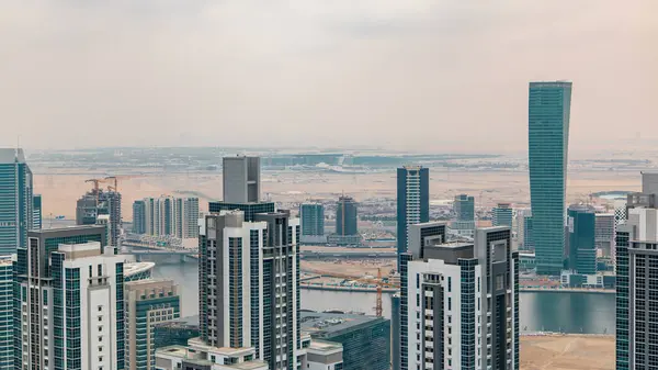 Dubai'nin iş bay önce günbatımı timelapse kuleleri. Çatı görünümü bazı gökdelenler ve yapım aşamasında yeni kuleleri. Bulutlu gökyüzü