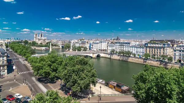 Cite Island ve Katedral Notre Dame de Paris ile Paris Panoraması Arap Dünya Enstitüsü gözlem güvertesinden bir zaman arkaplanı üzerinde. Üst Manzara. Yeşil ağaçlar, Seine nehri, mavi bulutlu gökyüzü. Fransa