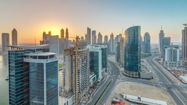 Dubai iş hangarı kuleleri, gün batımında hava saatinde. Bazı gökdelenlerin panoramik çatısı ve inşaat halindeki yeni kulelerin manzarası.
