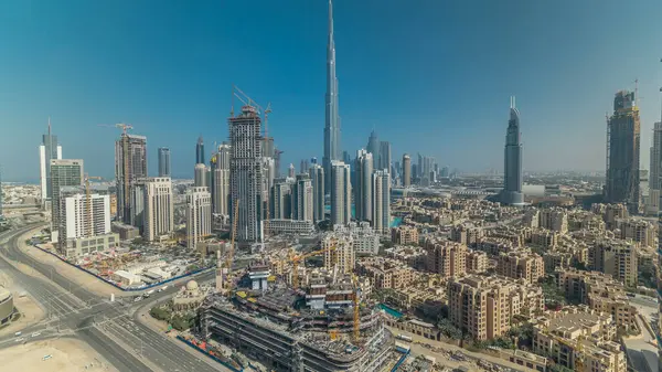 Dubai şehir merkezindeki güzel lüks hava manzarası, gölgeler, Dubai, Birleşik Arap Emirlikleri. Turuncu gökyüzünde renkli bulutlar olan iş hangarı kulelerinden çatı manzarası. Yolda trafik vardı.