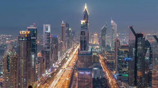 Dubai şehir manzarası gün gece geçiş timelapse için. Çok sayıda ışıklı Kuleli Şeyh Zayed Yolu üzerinde trafik çatı görünümü.