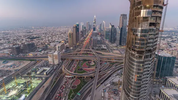 Dubai şehir merkezindeki ufuk çizgisi günden geceye geçiş zamanı. Şeyh Zayed kavşağındaki çok sayıda aydınlatma kulesiyle çatıdaki trafiğin görüntüsü.
