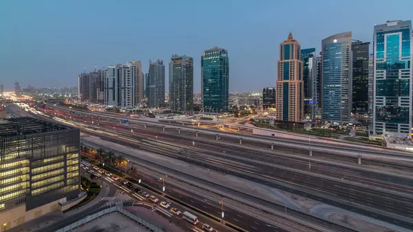 Jumeirah göl kulelerinin hava panoramik görüntüsü gökdelenler günden geceye geçiş zamanı Sheikh zayed yolu ve metro hattı trafiği.