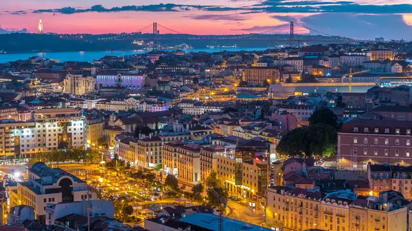 Lizbon 'da gün batımından sonra şehir merkezinin sonbahar gününden geceye geçiş zamanlarında kırmızı çatıları olan panoramik manzarası, Portekiz. Miradouro da Nossa Senhora do Monte bakış açısından üstten görünüm