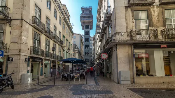 Santa Justa Elevator timelapse hyperlapse in Lisbon, Portugal. Blue sky on background. Connecting downtown to Bairro Alto. Historic buildings an a walking streets