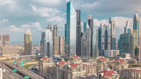 Dubai timelapse gökdelenler ve yol kavşağı havadan görünümü. Etrafında modern kuleleri ile şehir merkezinde kavşakta Trafik. Bulutlu gökyüzü