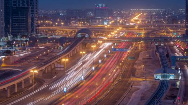 Dubai Marina 'dan Şeyh Zayed yoluna gece gündüz aydınlık gökdelenlerle geçiş zamanı, Dubai. Tramvayı olan trafik, köprüler ve metro istasyonları. Birleşik Arap Emirlikleri