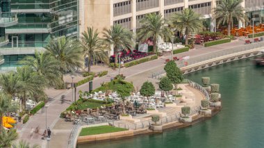 Dubai Marina Havaalanı 'nda bir restoranı olan bir rıhtım gezisi. Kanalda yüzen tekne ve yatlar. Dubai, Birleşik Arap Emirlikleri