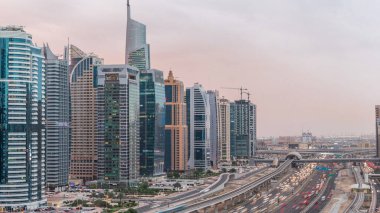 Dubai Marina ve Jlt gökdelenlerini, Dubai 'deki Şeyh Zayed yolunun hava görüntüsü gece gündüz geçiş zamanlarını çevreledi. Trafik ve metro hattı. Birleşik Arap Emirlikleri