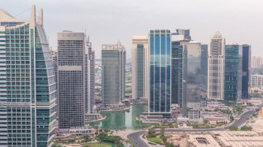 Jumeirah Lake Towers yerleşim bölgesi Dubai Marina yakınında havadan timelapse. Yukarıdan modern gökdelenler ve park