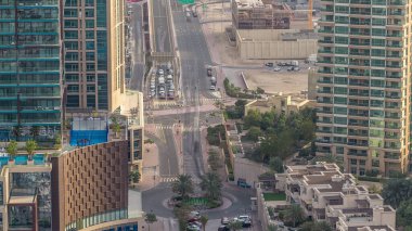 Bir büyük şehir timelapse bir yol kavşak hava görünümünü. Arabalar ve tramvay ile UAE Dubai Yat Limanı bölgesinin kentsel peyzaj