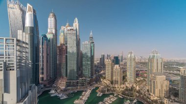Dubai Marina akşam timelapse havadan üst görünümü. Dubai, Bae'de gün batımından önce yüzen yatlar ve tekneler lezne ve kanal. Modern kuleler ve yolda trafik