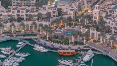 Dubai Marina'nın havadan üstten gündüz geceye geçiş saati. Dubai, Bae gün batımından sonra yüzen yatlar ve tekneler ile gezinti ve kanal. Işıklı binalar ve çeşme