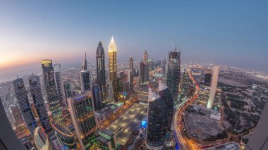 Sheikh Zayed Yolu yakınlarındaki binaların silueti ve Dubai, BAE 'deki hava gününden geceye geçiş. Günbatımından sonra finans merkezinde ve şehir merkezinde park yeri olan modern kuleler ve gökdelenler.