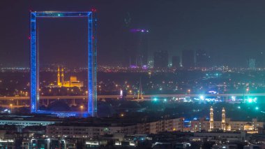 Zabeel Mescidi ile Dubai Çerçeve gece zaman atlamalı aydınlatılmış. Kum fırtınası sırasında yukarıdan havadan görünüm. Çerçeve Zabeel Park mimari bir dönüm noktası.
