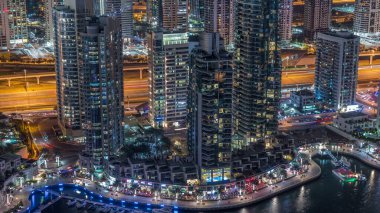Dubai Marina, gökdelenleri ve Jumeirah göl kulelerini aydınlattı. Birleşik Arap Emirlikleri 'nin en üst düzey hava gece zaman çizelgesinden. Yolda trafik vardı.