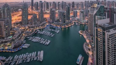 Dubai Marina, gökdelenleri ve Jumeirah göl kulelerini aydınlatmış ve Birleşik Arap Emirlikleri 'nde gece gündüz geçiş zamanlarına kadar panoramik manzara sağlamıştır. Yolda trafik ve yüzen tekneler.