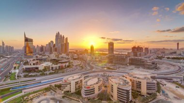 Modern binalar hava timelapse, Birleşik Arap Emirlikleri ile Dubai Media City üzerinde gün batımı. Dubai marina bir yolda trafik ile bir arka plan üzerinde