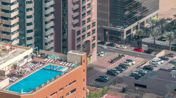 Çatı yüzme havuzu ile otopark yukarıda timelapse, Finans bölgesinde havadan üst görünümü manzaralı. İnsanlar rahatlıyor. Dubai, Birleşik Arap Emirlikleri