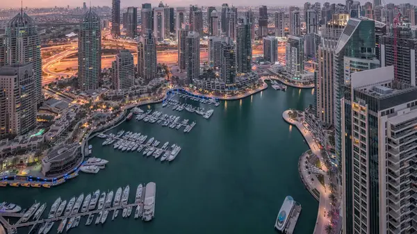 Dubai Marina, gökdelenleri ve Jumeirah göl kulelerini aydınlatmış ve Birleşik Arap Emirlikleri 'nde gece gündüz geçiş zamanlarına kadar panoramik manzara sağlamıştır. Yolda trafik ve yüzen tekneler.