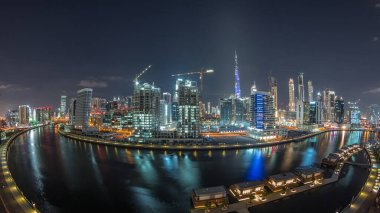 Parlak gökdelenleri olan gece şehri. Kanal ve şehir merkezindeki kulelerin yakınlarındaki hava zaman çizelgesi. İş Körfezi, Dubai, Birleşik Arap Emirlikleri 'nde.