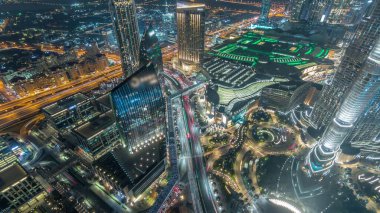 Dubai şehir caddesi yoğun trafik ve gökdelenler gece zaman aşımı etrafında. Alışveriş merkezi havadan manzaralı modern yol ve kentsel binalar. Şeyh Muhammed bin Reşid Blvd