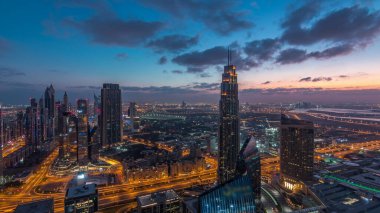 Dubai Uluslararası Finans Merkezi semt, gece den gündüze geçiş saati ne zaman ışıklı modern gökdelenler ile. Gün doğumundan önce sokaklarda trafik ile Downtown havadan görünümü