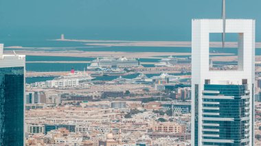 Bir arka plan üzerinde gökdelenler, evler ve liman Rashid ile Dubai timelapse Downtown havadan akşam görünümü, deniz seyir limanında kenetlenme gemileri, Bae
