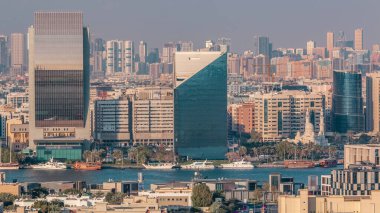 Deira ve Dubai deresinin hava manzarası tipik eski ve modern binalar zaman ayarlı. Arka planda Sharjah. Gökdelen çatısından bak. Dubai, Birleşik Arap Emirlikleri