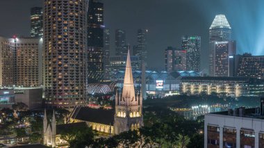 St. Andrew Katedrali 'nin gece uçuşu. Singapur 'un en büyük katedrali olan Anglikan katedrali. Arkaplanda gökdelenler