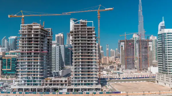 İnşaat halindeki gökdelenlerin havadan görünüşü Dubai 'de dev vinçler zaman ayarlı. Arka planda şehir merkezi olan bir işletme alanı. Birleşik Arap Emirlikleri
