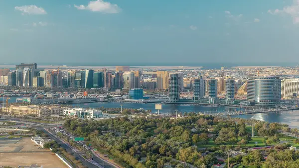 Deira 'daki yeni modern binaların ve arka planda deniz bulunan yeşil parkın hava manzarası güneşli Dubai Creek, Dubai' de, Birleşik Arap Emirlikleri 'nde
