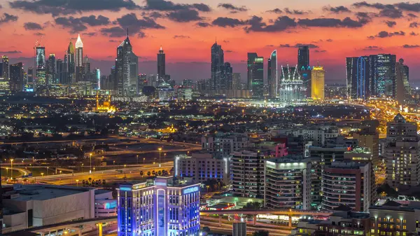 Şehir merkezinde büyük gökdelenler ve onlardan gelen ışıklar ve renkli gökyüzü, Dubai, Birleşik Arap Emirlikleri ile finans bölgesi Timelapse 'nin havadan görünüşü