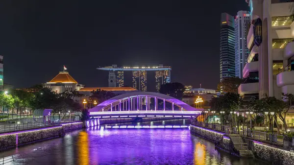 Singapur finans bölgesinin Skyline 'ı ve Elgin Köprüsü' nün arkasındaki Marina körfezi ve Singapur Nehri gece hipervanesi. Parlamento binası sol tarafta.