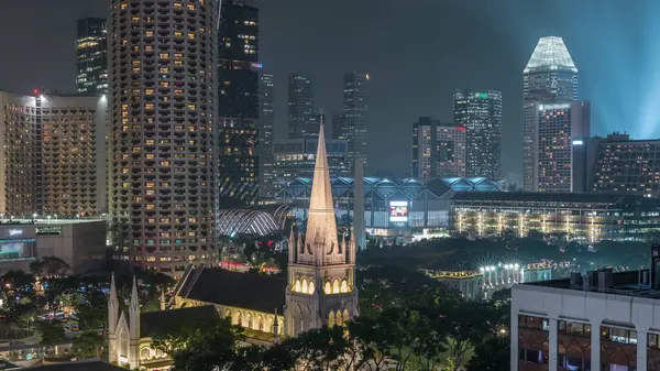 St. Andrew Katedrali 'nin gece uçuşu. Singapur 'un en büyük katedrali olan Anglikan katedrali. Arkaplanda gökdelenler