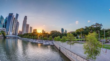 Singapur gökdelenleri üzerinde günbatımı beyaz Anderson Köprüsü ve Escplanade Park 'a yakın birkaç finans bölgesi kulesi ile gökdelen. Her iki tarafta da yeşil yapraklar var..