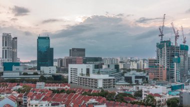 Çin Mahallesi 'nin kırmızı çatıları ve Merkezi İş Bölgesi gökdelenleri, Singapur. Eski ve modern binalar arasındaki zıtlık. İnşaat alanı ve gün batımından önce caddelerde trafik