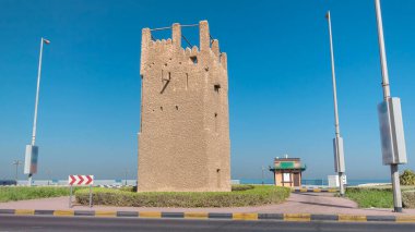 Ajman zaman kulesinin mavi gökyüzü ve yoldaki trafik hızını izleyin. Birleşik Arap Emirlikleri