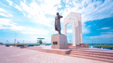 Aktau, Kazakistan 'daki Zhalau Mynbayev Timelapse Hiperlapse anıtı. Hazar Denizi ve Mavi Bulutlu Gökyüzü Sakin Bir Yaz Günü 'nde Saygıdeğer bir zemin oluşturdu